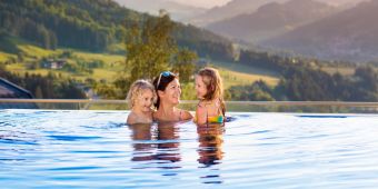 Mutter und Kinder spielen im Infinity-Freibad