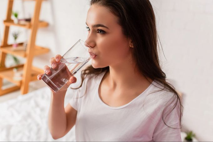 Genug zu trinken, ist generell von Belang – und erst recht, wenn man abnehmen möchte. Frau trinkt Wasser.