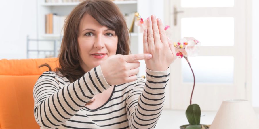 Frau tappt auf den Karate-Punkt an der Hand. EFT-tapping.