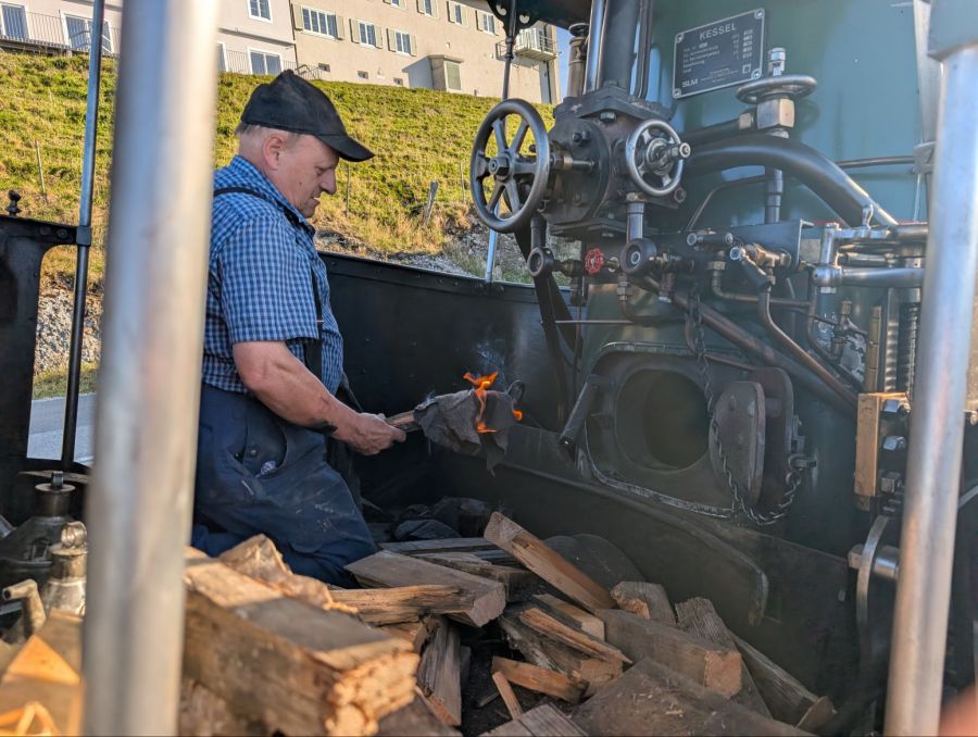Der Heizer entfacht das Feuer.