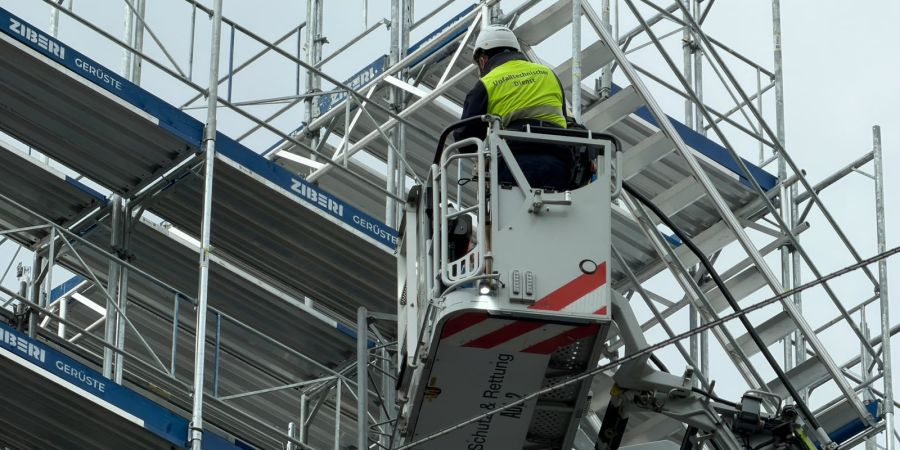 Ein Mitarbeiter von Schutz & Rettung untersucht das Gerüst an der Unfallstelle in Zürich. Zuvor war es dort zu einem schweren Zwischenfall gekommen.