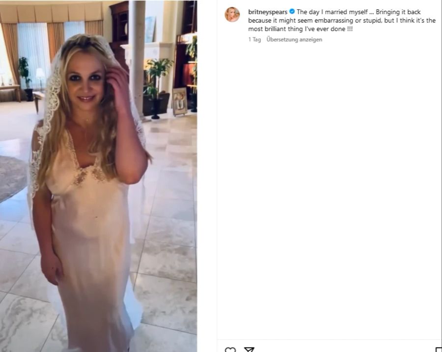 Britney Spears lächelt mit Schleier und Brautkleid glücklich in die Kamera.