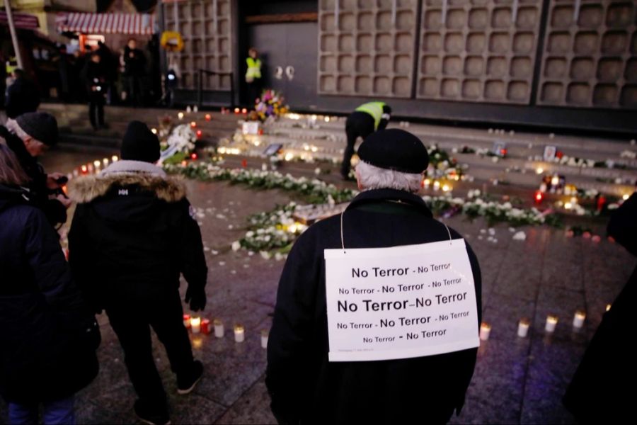 Ein Trauernder mahnt mit seinem Schild gegen den Terror. (Archivbild)