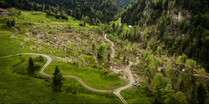 Eine Luftaufnahme zeigt den Hangrutsch unterhalb des Bauernhauses und Landwirtschaftsbetriebs. Luftaufnahme