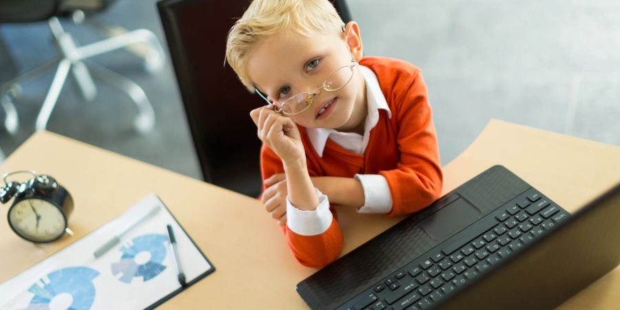 Junge mit Brille am Schreibtisch