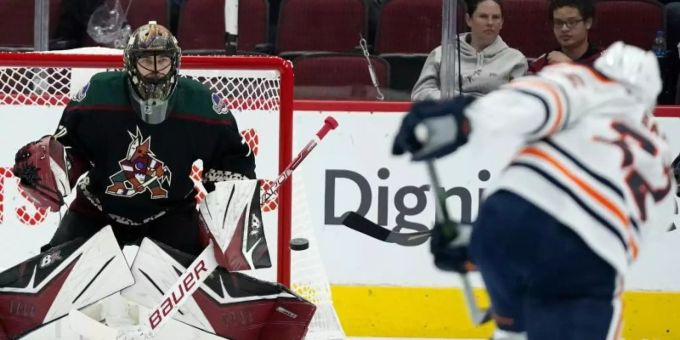 Oilers-Profi Tyson Barrie feuert einen Schuss in Richtung Coyotes-Goalie Karel Vejmelka ab. Foto: Ross D. Franklin/AP/dpa Oilers-Profi Tyson Barrie feuert einen Schuss in Richtung Coyotes-Goalie Karel Vejmelka ab. Foto: Ross D. Franklin/AP/dpa