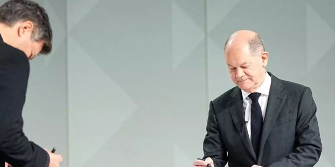 Der Grünen-Vorsitzende Robert Habeck (l) und der neue Kanzler Olaf Scholz (SPD) setzen ihre Unterschriften unter das Dokument. Foto: Michael Kappeler/dpa Der Grünen-Vorsitzende Robert Habeck (l) und der neue Kanzler Olaf Scholz (SPD) setzen ihre Unterschriften unter das Dokument. Foto: Michael Kappeler/dpa