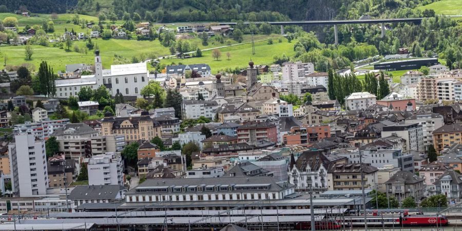 Blick auf Brig mit der A9 Simplonstrasse, der Kollegiumskirche, dem Stockalperpalast sowie der Iischi Arena und dem Bahnhof.