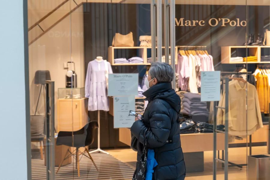 Eine Frau vor dem Schaufenster eines geschlossenen Geschäfts in Linz.