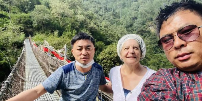 Fran Bak steht auf einer Hängebrücke mit ihrem Guide Gembo NB (l) und ihrem Fahrer Tashi Tshering. Sie ist seit der Pandemie die erste Touristin, die Urlaub im Königreich Bhutan machen darf. Foto: Privat/Fran Bak/dpa Fran Bak steht auf einer Hängebrücke mit ihrem Guide Gembo NB (l) und ihrem Fahrer Tashi Tshering. Sie ist seit der Pandemie die erste Touristin, die Urlaub im Königreich Bhutan machen darf. Foto: Privat/Fran Bak/dpa
