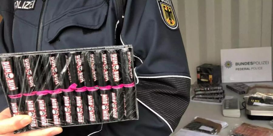 Ein Bundespolizist zeigt beschlagnahmte Böller. Foto: Gregor Bauernfeind/dpa