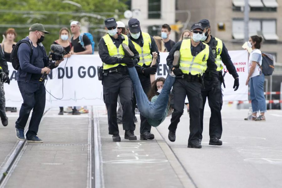 Polizisten tragen am 20. Juni 2020 eine Aktivistin von Extinction Rebellion von der Quaibrücke in Zürich.