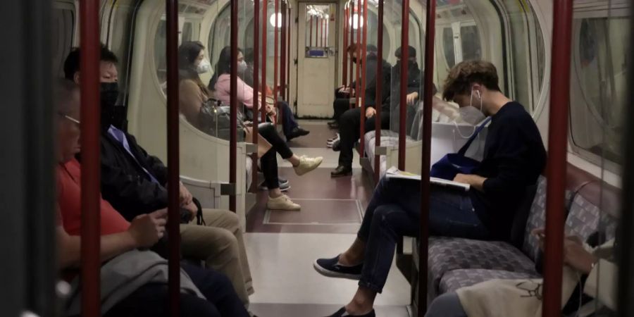 Mehrere Passanten tragen in der Londoner U-Bahn im Oktober eine Maske – freiwillig, denn die Maskenpflicht ist aufgehoben. Das kritisieren Wissenschaftler.