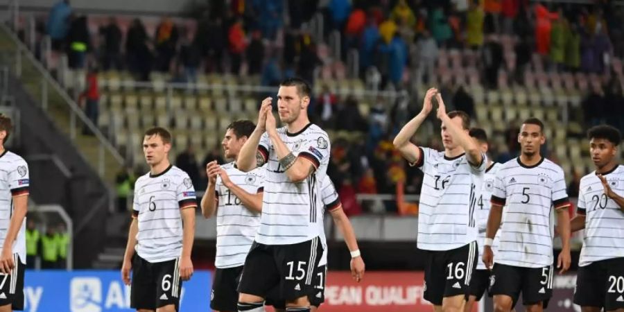 Die Deutsche Mannschaft feiert die erfolgreiche Qualifikation für die Weltmeisterschaft 2022 in Katar mit den Zuschauern auf der Tribüne. Foto: Federico Gambarini/dpa