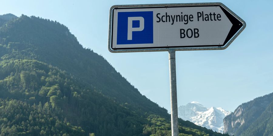 Ein Parkplatzwegweiser Schynige Platte in Wilderswil. Im Hintergrund die Jungfrau.