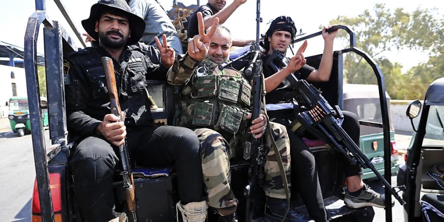 Kämpfer von Saraya al-Salam («Friedenskompanie»), dem militärischen Flügel des schiitischen Geistlichen Al-Sadr, sitzen in einem Fahrzeug. Nach der Gewalteskalation im Irak hat sich die Lage in der Hauptstadt Bagdad wieder beruhigt. Foto: Murtadha Ridha/AP/dpa