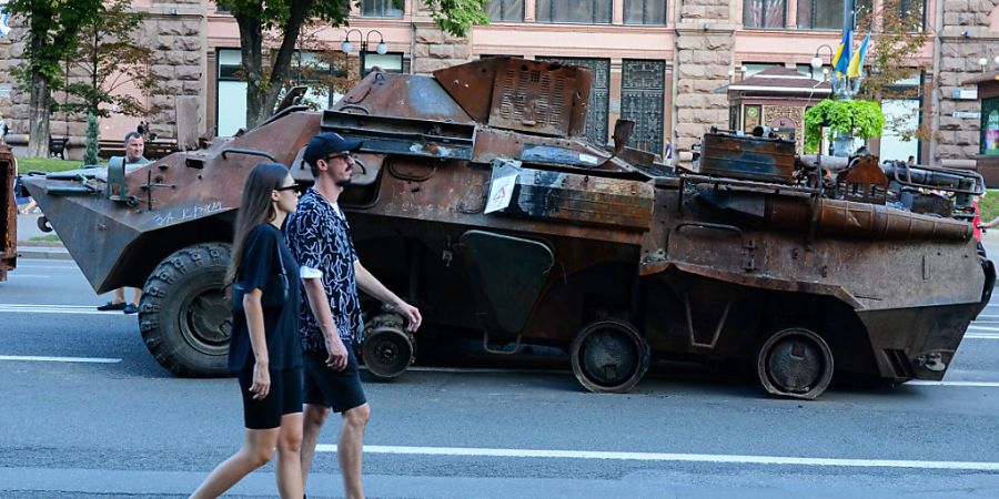 Menschen gehen an der zerstörten Ausrüstung der russischen Armee, die in der Khreschatyk Strasse im Zentrum von Kiew ausgestellt ist. Foto: Aleksandr Gusev/SOPA Images via ZUMA Press Wire/dpa