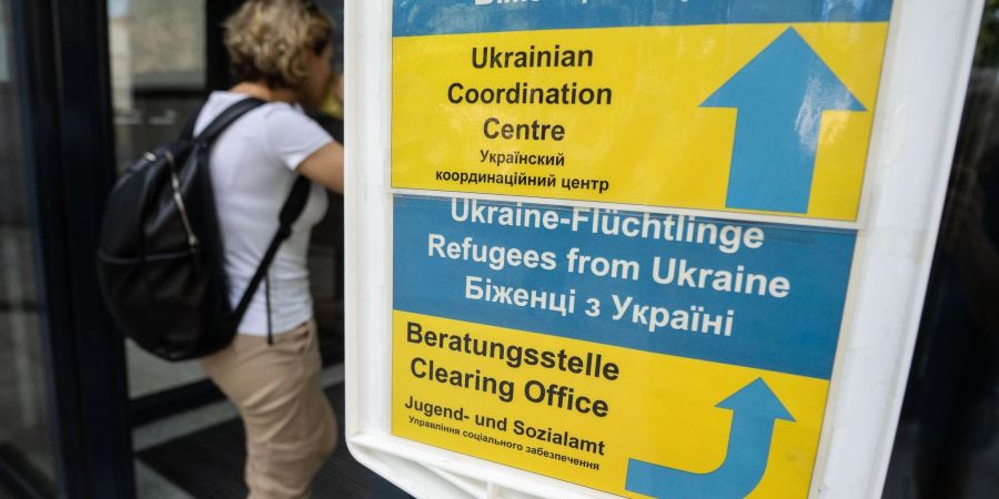 Eine Besucherin geht an einem Hinweisschild der Initiative Ukrainian Coordination Center im Amt für multikulturelle Angelegenheiten in Frankfurt am Main vorbei.