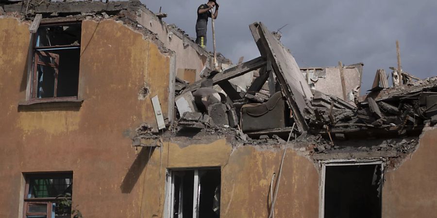 Ein Feuerwehrmann steht auf dem Dach eines Hauses in Slowjansk, das durch Beschuss des russischen Militärs schwer beschädigt wurde. Foto: Leo Correa/AP/dpa