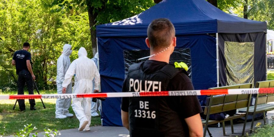 Beamte sichern in einem Faltpavillon im kleinen Tiergarten Spuren.