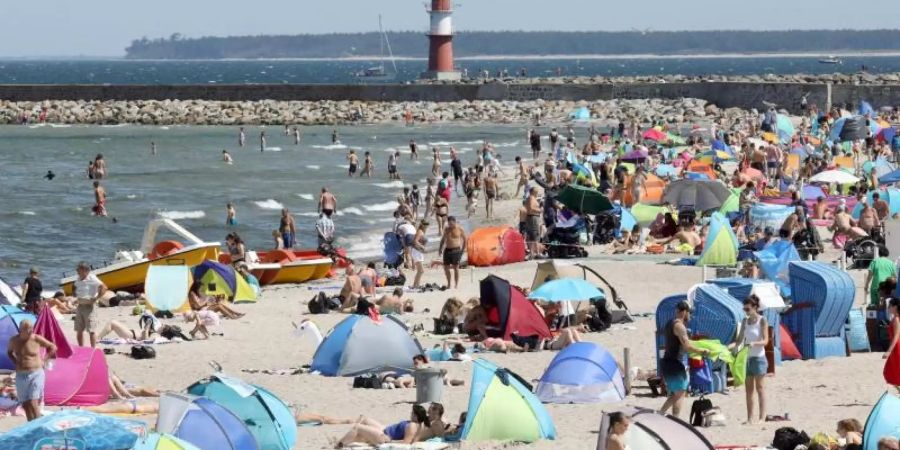 Am Ostseestrand von Warnemünde herrscht Hochbetrieb. Strandmuscheln und Sonnenschirme bestimmen das Bild. Foto: Bernd Wüstneck