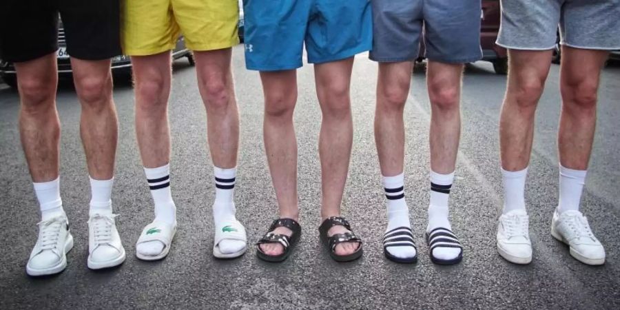 Voll im Trend: Sneaker und Badelatschen mit weissen Tennissocken. Foto: Alexander Blum