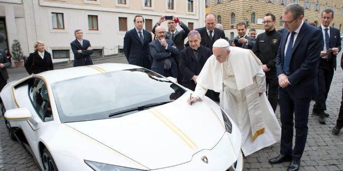 Papst Franziskus signiert einen weissen Lamborghini, der ihm vom italienischen Sportwagenhersteller geschenkt wurde. Papst-Lamborghini versteigert