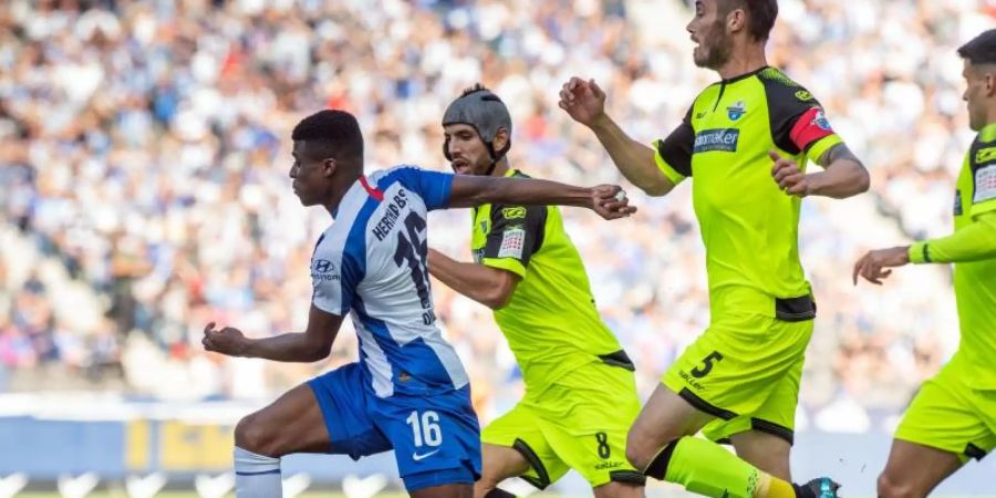 Hertha-Spieler Javairo Dilrosun (l) setzt sich gegen eine Gruppe Paderborner durch und erzielt das 1:0. Foto: Soeren Stache