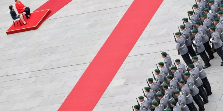 Merkel im Sitzen beim Empfang mit militärischen Ehren