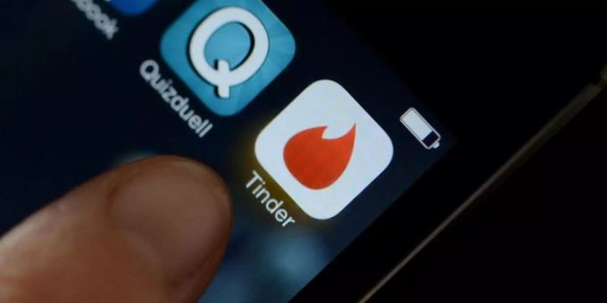 Logo der App Tinder auf einem Smartphone. LGBT Tinder Logo App