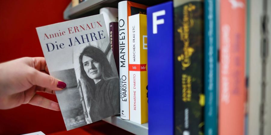 Eine Frau zieht das Buch «Die Jahre» von Annie Ernaux in einer Leipziger Buchhandlung aus dem Regal. Die französische Schriftstellerin Annie Ernaux erhält den Literaturnobelpreis.