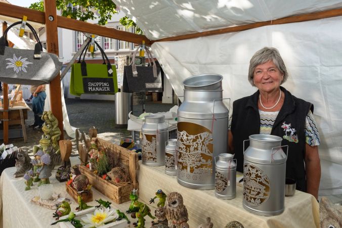 Milchkannen mit Scherenschnitte von Esther Gerber am Stand von Barbara Antenen.