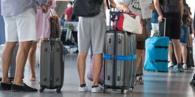 Touristen mit Koffern am Flughafen. Coronavirus