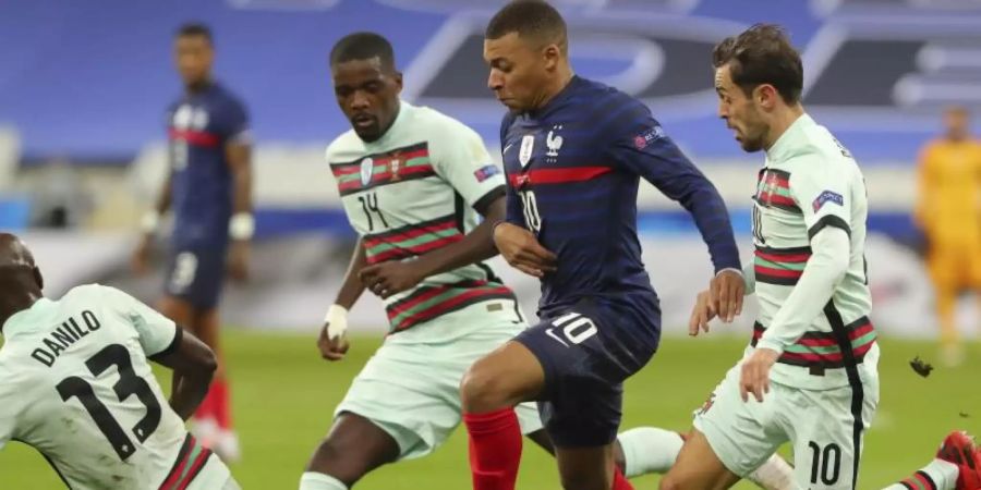 Der Franzose Kylian Mbappe (2.v.r) wird von drei Portugiesen bedrängt. Foto: Thibault Camus/AP/dpa
