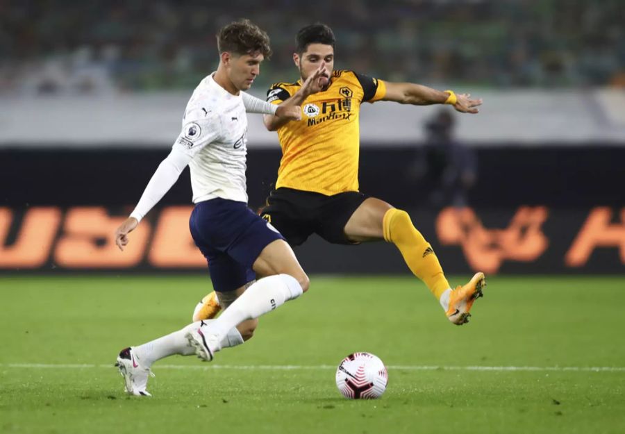 John Stones (l.) kommt vor Pedro Neto (r.) an den Ball.