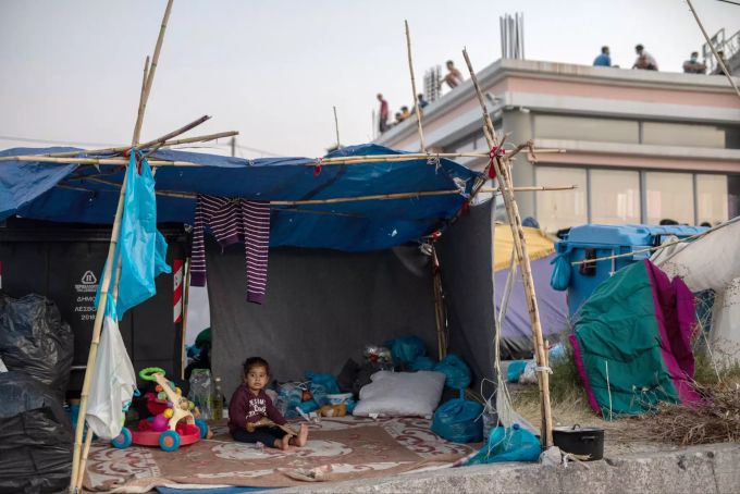 Ein Kind sitzt in einem provisorischen Zelt entlang einer Strasse, welche von Moria nach Mytilene führt. Flüchtlingslager Moria