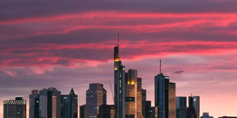 Bei Sonnenuntergang ist die Skyline der Bankenstadt in ein rötliches Licht getaucht. Foto: Arne Dedert/dpa