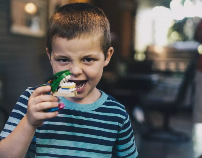 Kinder brauchen die richtige Zahnpflege. Kind mit Krokodil