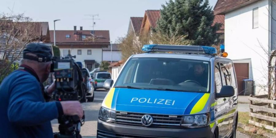 Ein Mannschaftswagen der Polizei steht vor einem Haus in Vogtareuth, in dem drei Tote Menschen aufgefunden worden waren. Foto: Lino Mirgeler/dpa