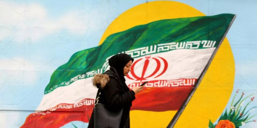 Eine Frau vor der iranischen Flagge in Teheran