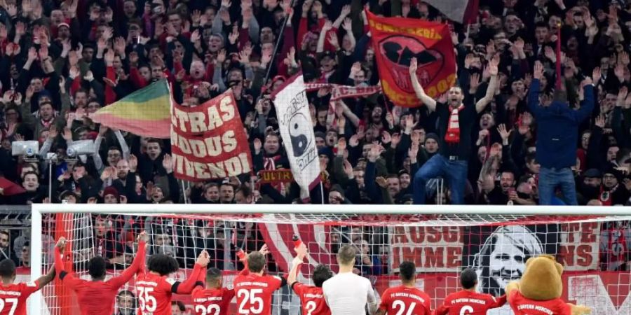 Jubel bei Fans und Spielern: Der FC Bayern hat mit 3:2 gewonnen. Foto: Peter Kneffel/dpa