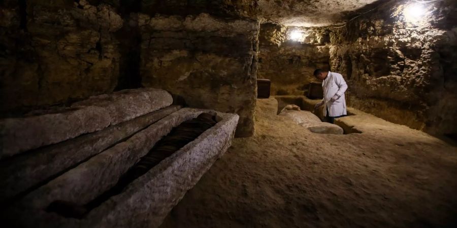 Ein Archäologe arbeitet in einem der drei neu entdeckten Gemeinschaftsgräber der Hohepriester der altägyptischen Gottheit Djehuty in der archäologischen Stätte Al-Ghoreifa