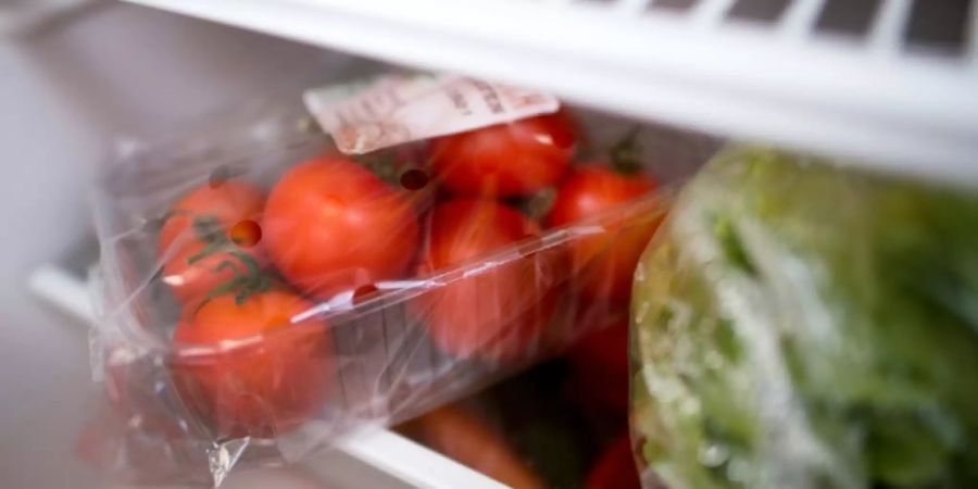 In Plastik verpackte Tomaten und Salatherzen