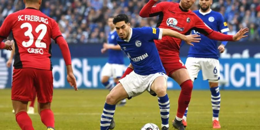 Schalkes Suat Serdar gegen Freiburgs Lucas Höler (r) im Zweikampf um den Ball. Foto: Ina Fassbender