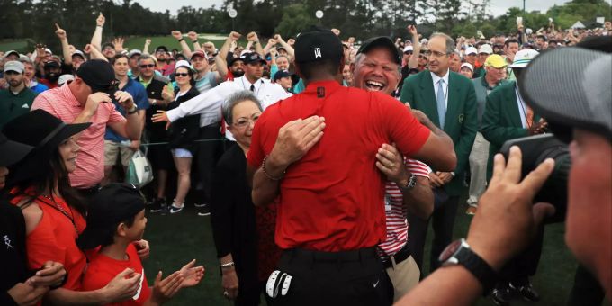 Erica Herman (links in Rot mit Hut) hält sich dezent zurück. tiger woods