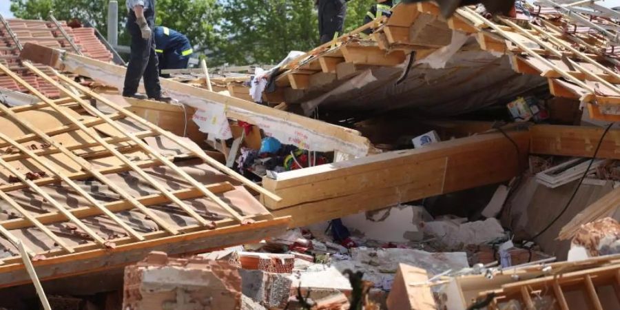 Einsatzkräfte in den Trümmern des zerstörten Hauses im bayerischen Rettenbach. Foto: Karl-Josef Hildenbrand