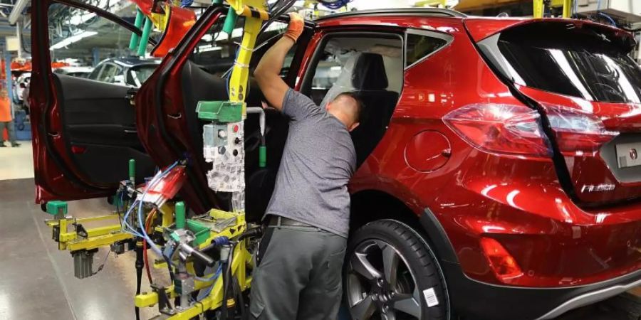 Ein Mitarbeiter baut im Ford-Werk in Köln eine Tür in einen Ford Fiesta ein. Foto: Oliver Berg