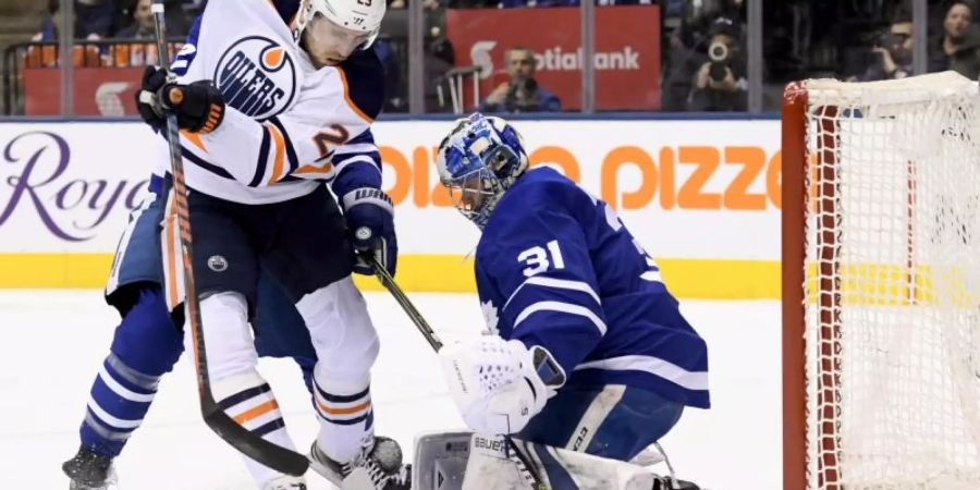 Edmontons Leon Draisaitl (l/29) in Aktion Gaolie Frederik Andersen (31) von den Toronto Maple Leafs. Foto: Nathan Denette/The Canadian Press