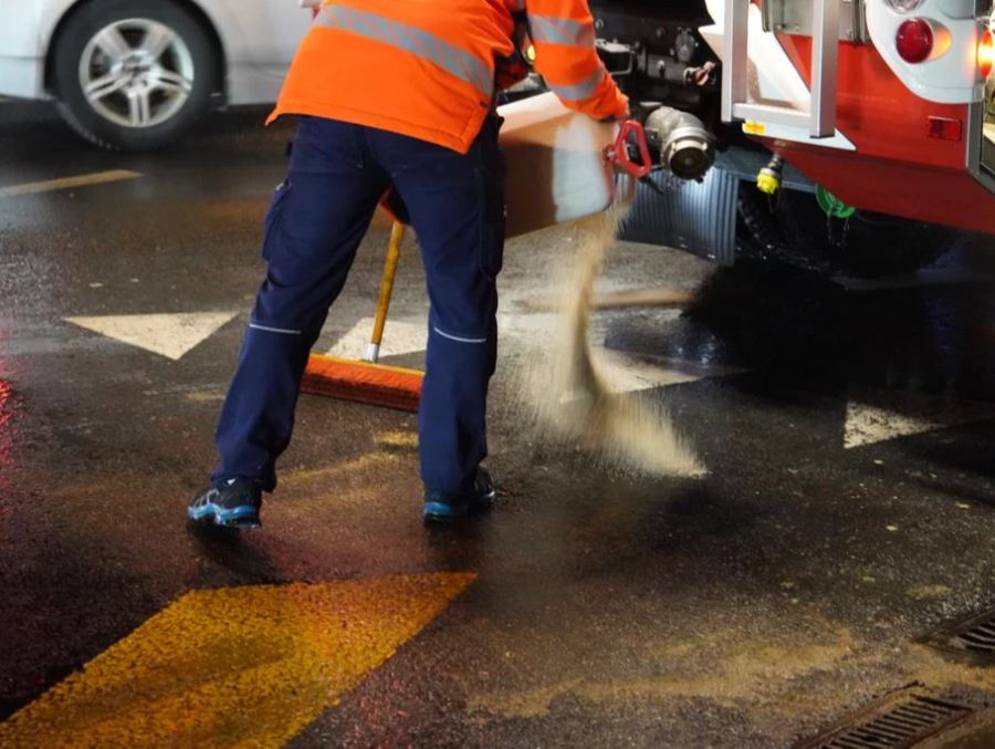 Die Feuerwehr salzt die Stelle, an der die Masse austrat.
