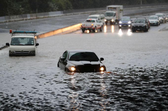 Fahrzeuge stehen im Hochwasser einer überschwemmten Strasse im neuseeländischen Auckland. Dean Purcell/New Zealand Herald/dpa Wetter in Neuseeland